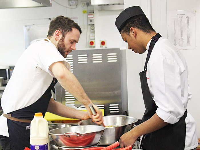 Adam helps out a student with their dessert prep 