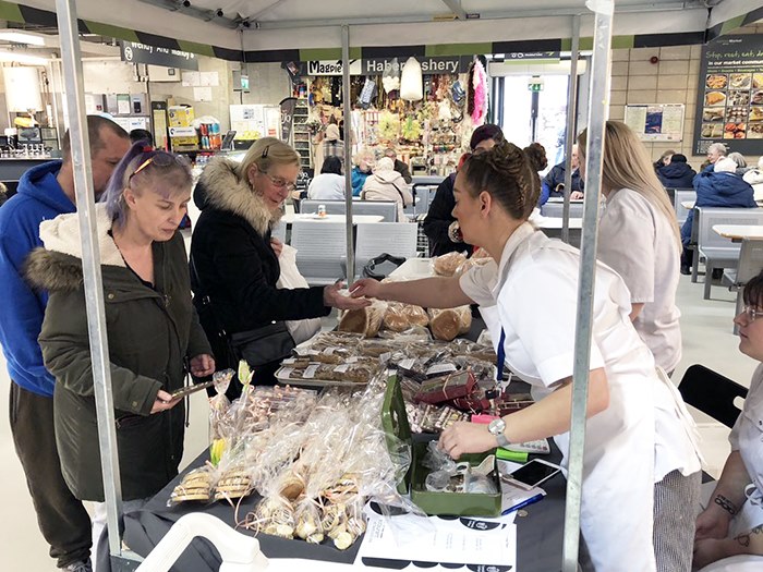 Students serving customers on the stall