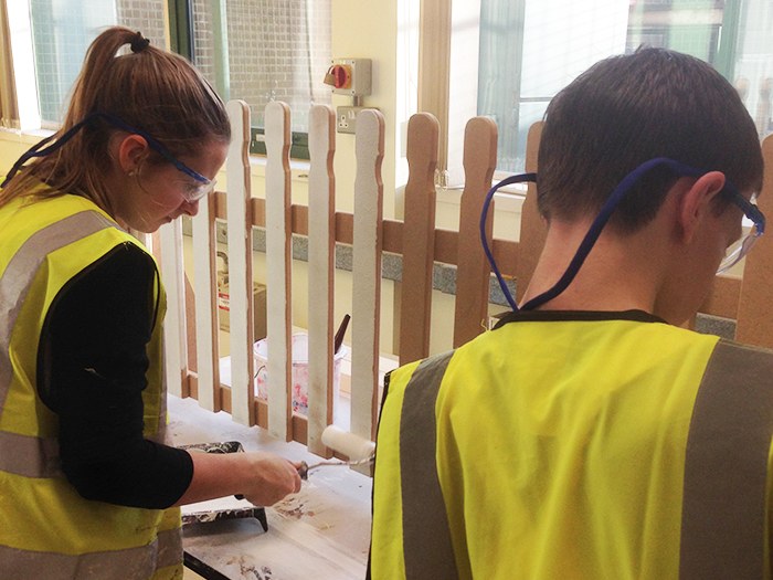 Students paint the finished fence